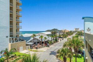 A coastal hotel with balconies, a beach view, and a restaurant.