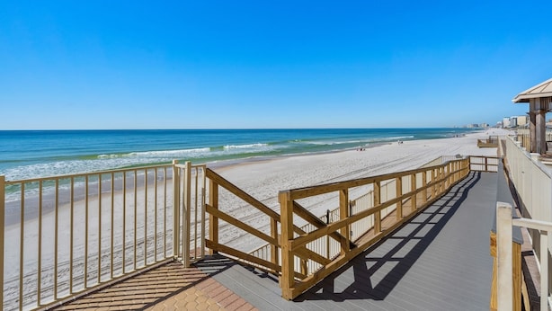 A wooden boardwalk leading to a beach with a clear blue sky. - Oceanfront escape - pool, hot tub & attraction tickets (Panama City Beach)