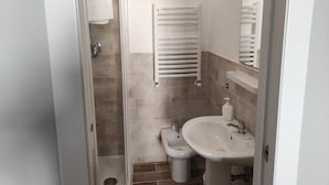 A bathroom with a shower, a bidet, a sink, and a towel rack. - Hotel Big Bang (Rome)
