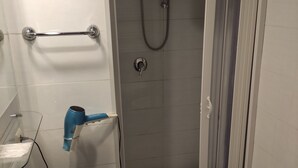 A bathroom with a shower, two sinks, a towel rack, and a hairdryer. - Hotel Big Bang (Rome)