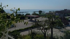 Une vue d’une zone côtière avec une station-service, un parking et des bâtiments en arrière-plan.