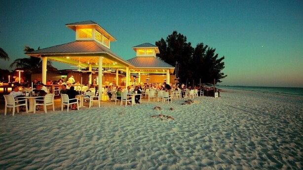 A beachside restaurant with outdoor seating and a covered area, overlooking the ocean. - Bay & Gulf Views. Waterfront+heated quiet pool+AC+2-minute walk to beach (Bradenton Beach)