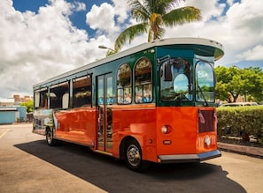 A vintage bus with a green and orange exterior parked on a street.