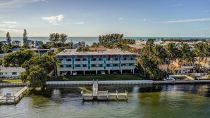 A hotel with a pool, a dock, and a view of the ocean. - Bay & Gulf Views. Waterfront+heated quiet pool+AC+2-minute walk to beach (Bradenton Beach)