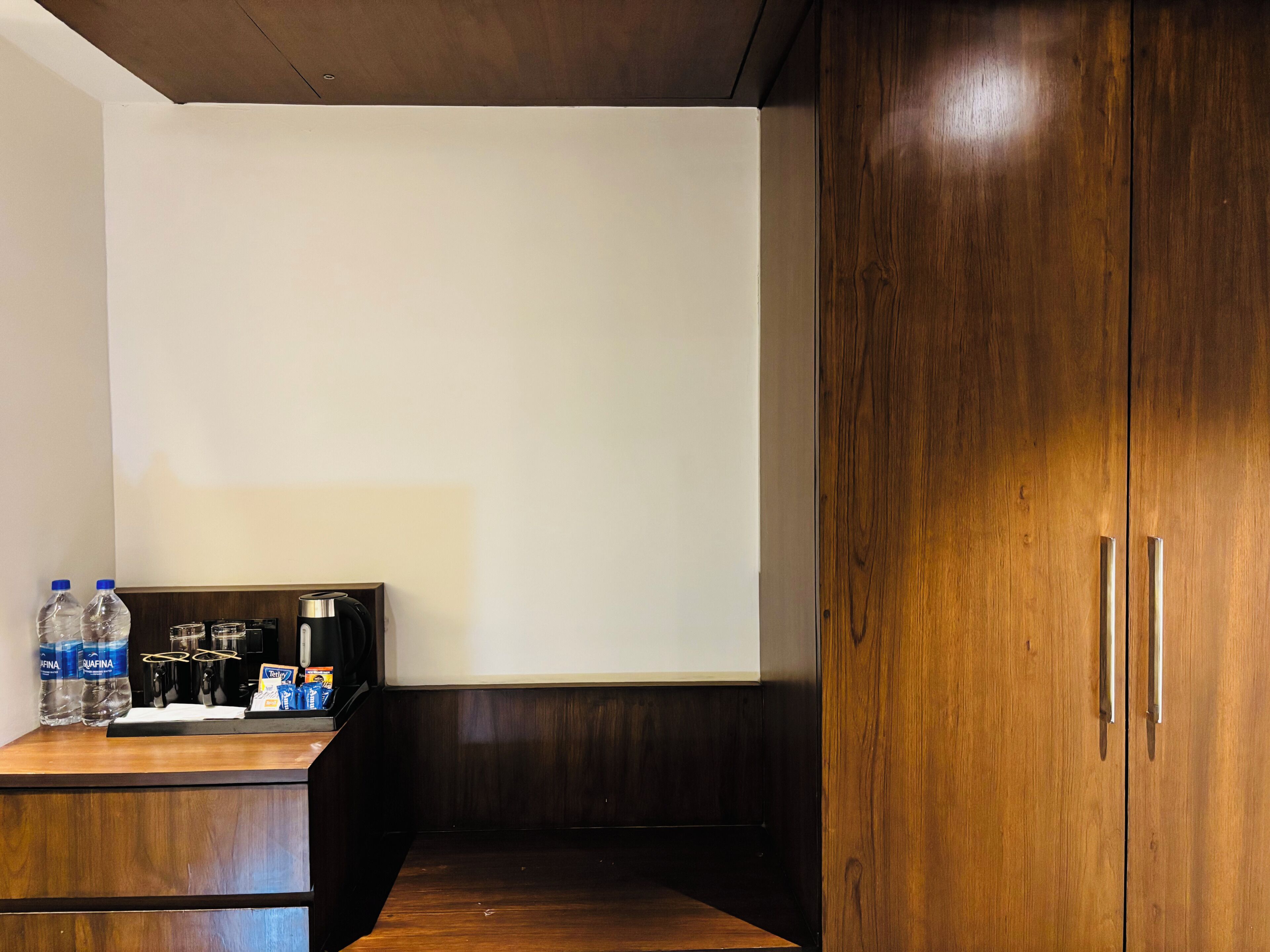 A kitchenette with a coffee maker, water bottles, and a box of tissues.