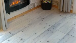 A living room with a fireplace, a flat-screen TV mounted on the wall, and a patterned wallpaper. - Baie de st valéry/somme le crotoy, cosy mobi-loft + hamman, sauna option (arrest)