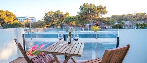 Enjoy a romantic evening on the balcony with a view of the pool and surrounding architecture.