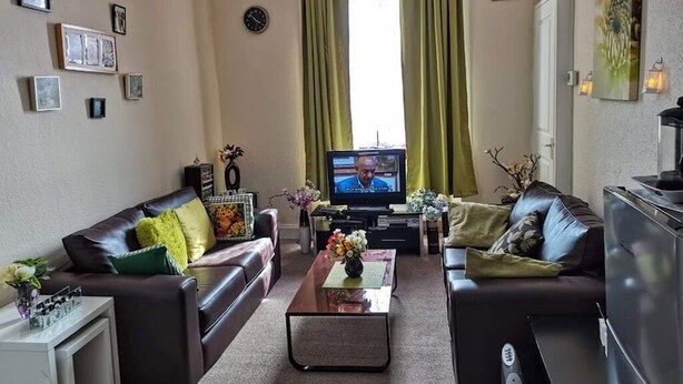 Ein Wohnzimmer mit zwei Sofas, einem Couchtisch, einem Fernseher und einem Schrank.
