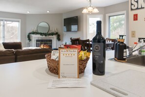 Un comptoir de cuisine avec une bouteille de cabernet sauvignon, un formulaire de commentaires et un panier de fruits.