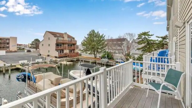 Ein Balkon mit Blick auf eine Marina, vertäuten Booten und Wohnhäuser.