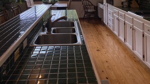 Uma cozinha moderna com uma ilha grande, piso de madeira e vista para o exterior.