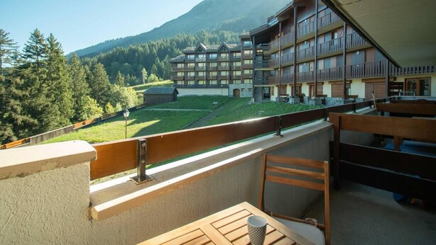 A balcony with a view of a mountain and a building with multiple floors and balconies. - 5m from ski slopes, 4th floor, view mountain, balcony, ski locker, 25m², Valmorel (Valmorel)