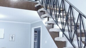 A multi-level interior with a staircase featuring a black metal railing and white steps. - The Hidden Gem - Huge Floor Plan - Game Room (Sulphur)