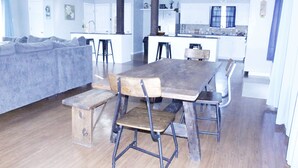 A modern kitchen with white cabinets, a wooden dining table, and bar stools. - The Hidden Gem - Huge Floor Plan - Game Room (Sulphur)
