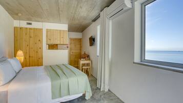 Una camera da letto con un letto, pareti in legno, un tavolino, una TV e una finestra con vista.