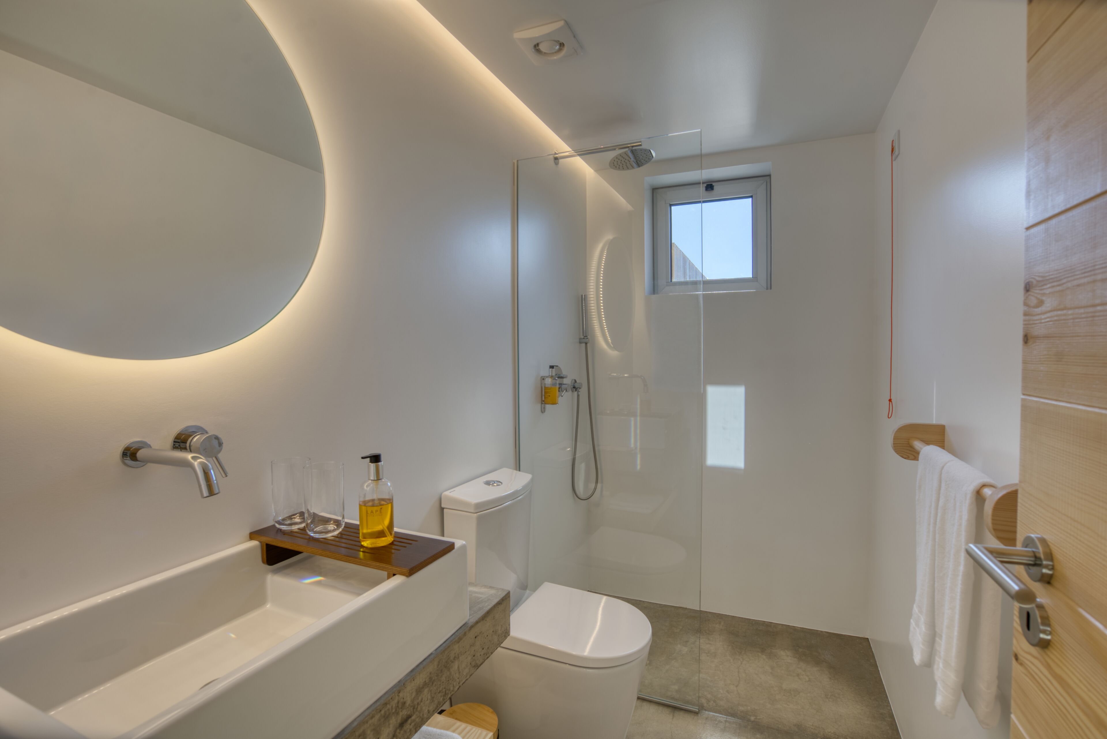 Un baño moderno con bañera, inodoro y ducha con mampara de vidrio.
