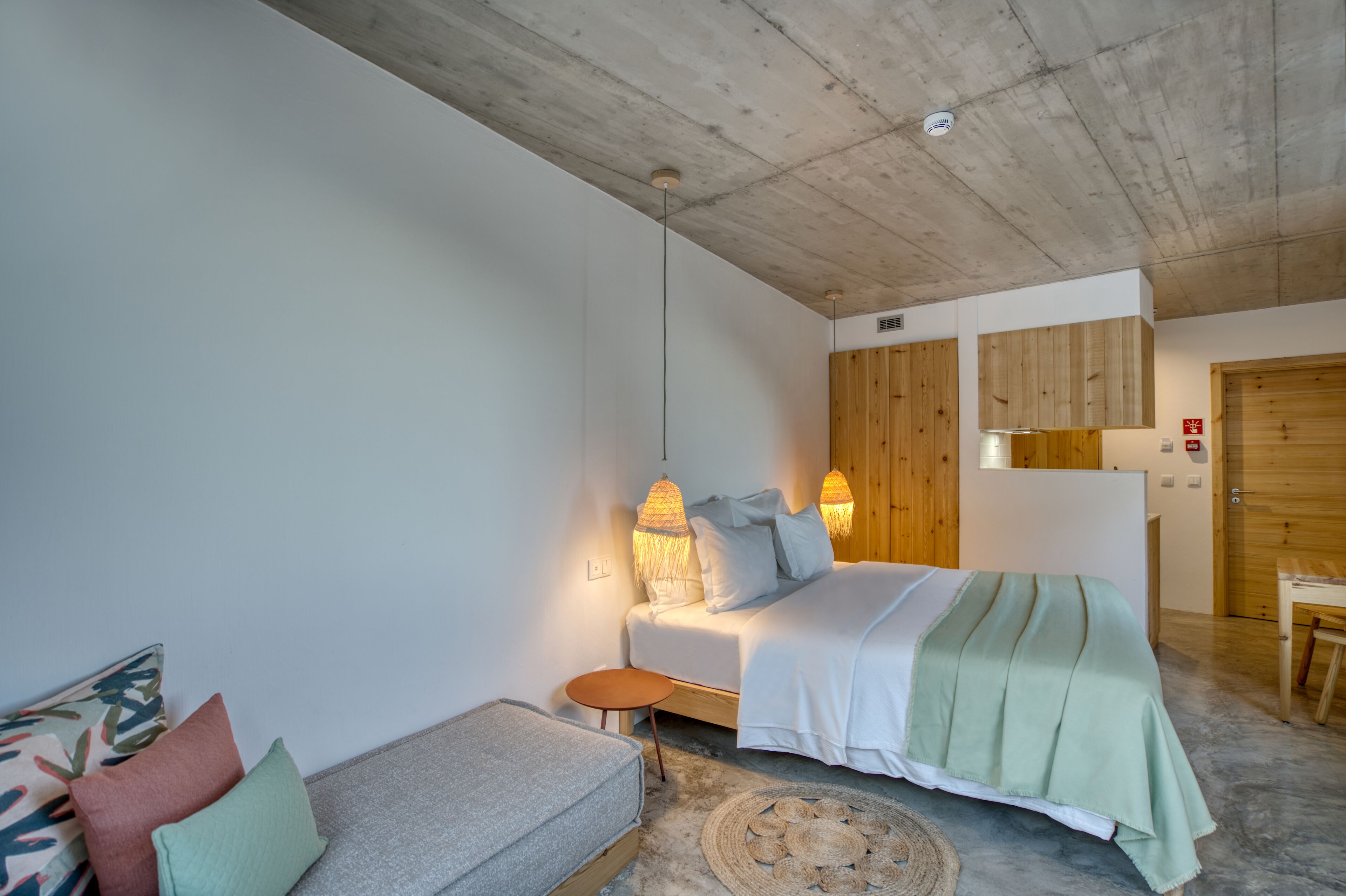 Una camera da letto moderna con un letto, comodini, un divano e un'armadio in legno.