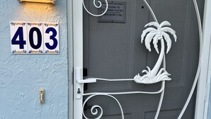 Una puerta con un diseño metálico decorativo, una placa con el número '403' y un cartel de bienvenida.