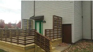 A building with a gated entrance, a green door, and a brown door.
