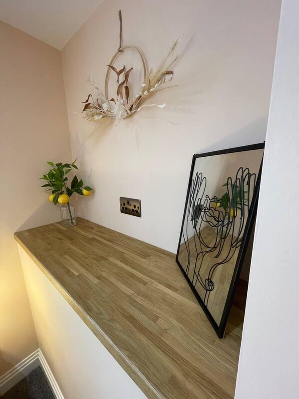 Un plan de travail en bois agrémenté d’un vase de citrons et d’un élément décoratif mural.