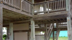 Une structure en bois à plusieurs niveaux, dotée d’un balcon et d’un escalier.