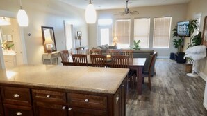 Una cocina con armarios de madera, encimera de granito y comedor con sillas y una mesa.