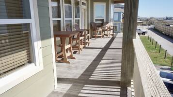 Un balcon doté de mobilier en bois et offrant une vue sur la plage.