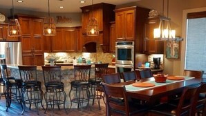 Cocina amplia con armarios de madera, una isla central y taburetes de bar.