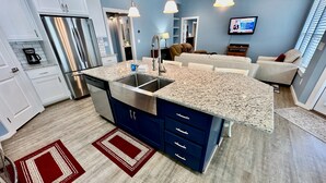 A modern kitchen with granite countertops, stainless steel appliances, and a central island. - PARKERSON HOUSE in Larry's Harbor POC (Port O'Connor)