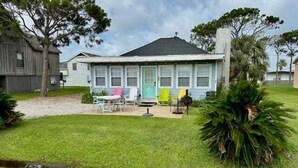 A two-story house with a front porch, a small lawn, and a tree. - SIREN COVE is Close to Beach in POC (Port O'Connor)