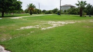 A grassy area with a path leading to a building.