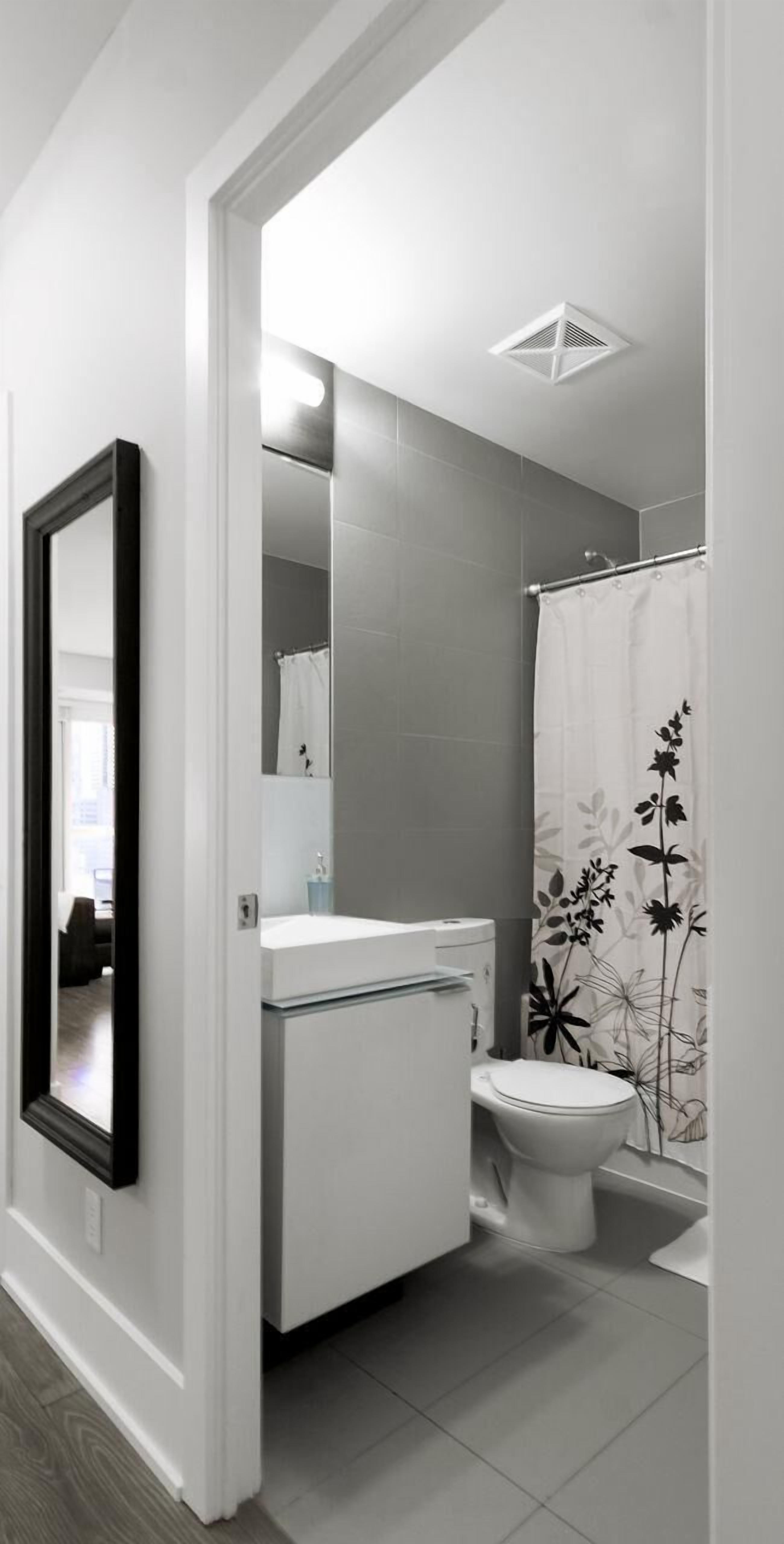 Un baño moderno con inodoro, lavamanos y ducha.