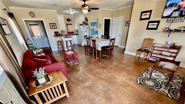 A spacious living room with a red sofa, wooden coffee table, and a dining area with a table and chairs. - UNCLE WOODY'S #1 in POC-Pets ok but add Fees (Port O'Connor)