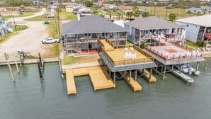 A waterfront property with a dock, a covered deck, and a building with multiple levels.