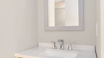 A bathroom with a white countertop, three faucets, and a mirror.