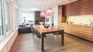 Eine moderne Küche mit Holzschränken und einem Essbereich mit Holztisch und Stühlen.
