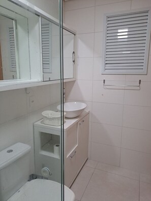 Un baño con inodoro, lavamanos y espejo.