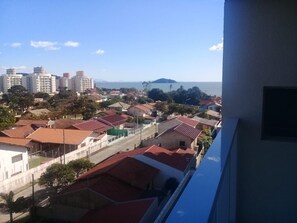 Zona residencial con casas de techo rojo, una montaña distante y edificios altos.