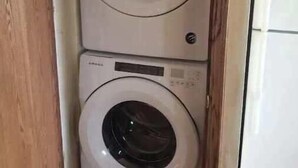 Ein kleiner Waschraum mit zwei Türen, einer Holztür und einer weißen Wand.