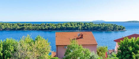 A coastal property with a view of the sea and a small island in the distance.