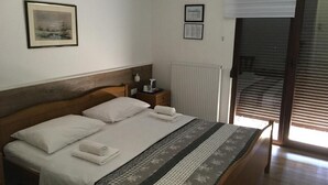 Un lit bien fait, avec une tête de lit en bois, une table de chevet avec une lampe et un tableau encadré accroché au mur.