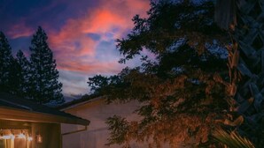 A hot tub on a wooden deck with a wooden railing and a palm tree. - Pool Sunset View Game Room Full Kitchen (Redding)