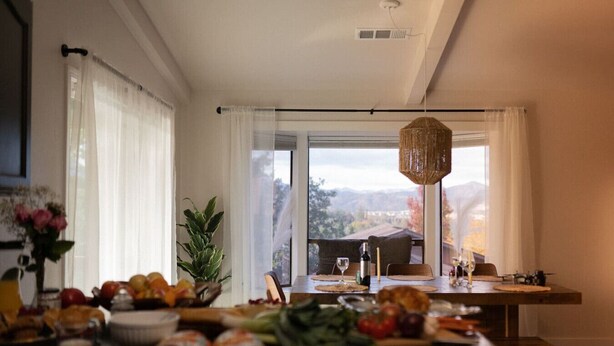 A dining area with a table set for two, a potted plant, and a view of the outdoors. - Pool Sunset View Game Room Full Kitchen (Redding)