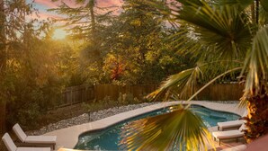 A swimming pool with lounge chairs and a palm tree. - Pool Sunset View Game Room Full Kitchen (Redding)