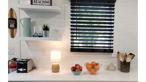 Una cucina con un tostapane, una lampada, una ciotola di frutta e un cartello con la scritta 'BEACH'.