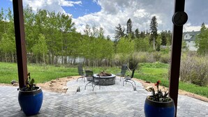 An outdoor patio with a circular seating area, a fire pit, and potted plants. - Private, Cozy, and Remote Mountain Apartment in Walk-Out Garden Level w/Patio. (Black Hawk)