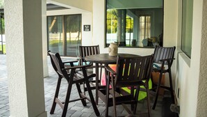 An outdoor patio area with a round table and six chairs. - Spacious & Private Guest Pool House Oasis (Orlando)