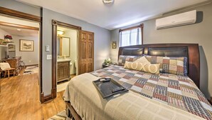 Een slaapkamer met een groot bed, een houten hoofdbord, een sprei en een dienblad met een afstandsbediening.