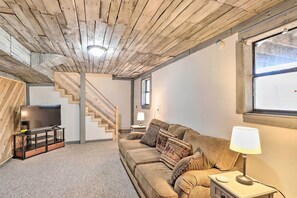 Relax in this inviting living room with a sofa, flat-screen TV, and staircase leading to additional space.
