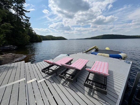 Peaceful lakeside dock with cozy lounge chairs and paddle boats